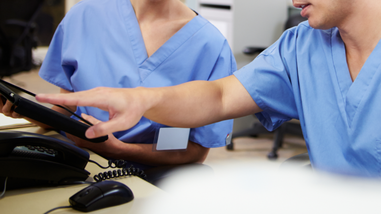 Two medical physicians working together on a tablet